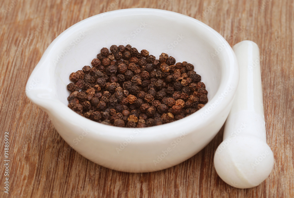 Black peppercorn on a mortar with pestle Black peppercorn on a mortar with pestle