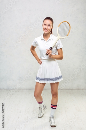 Beautiful girl in tennis dress, standing with a tennis racket in © Aleksey Sergeychik