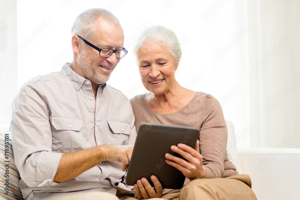 happy senior couple with tablet pc at home