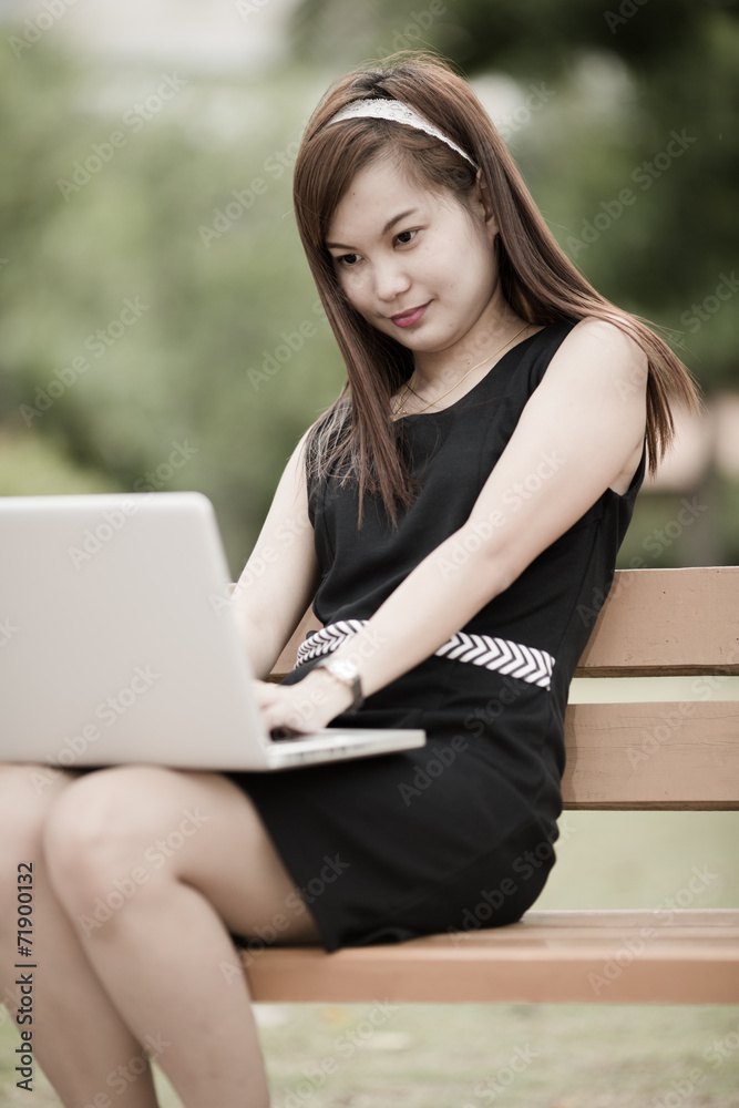 Beautiful young woman using laptop in park Beautiful young woman using laptop in park