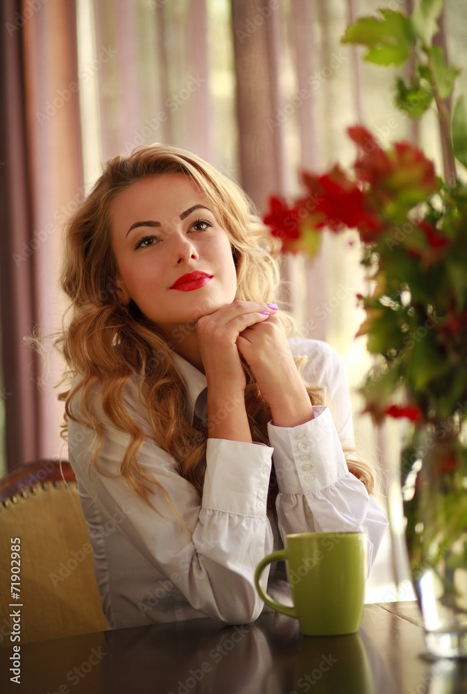 Beautiful woman sitting in a restaurant and dreamy looking up Beautiful woman sitting in a restaurant and dreamy looking up