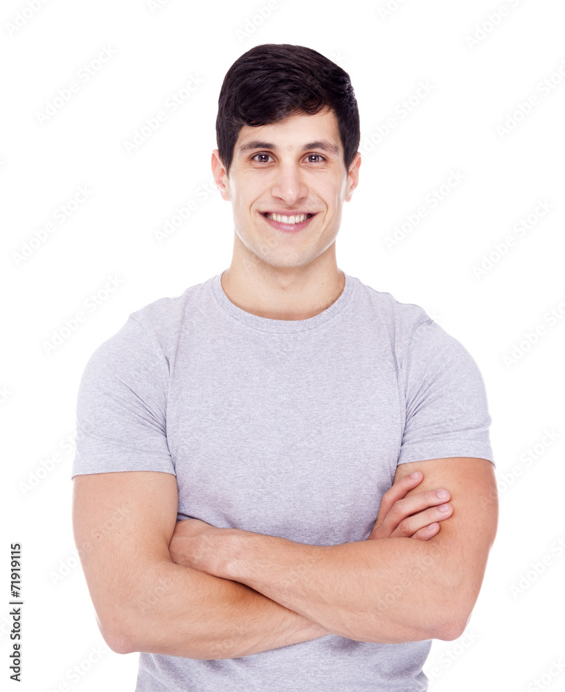 Smiling young casual man looking at camera with arms crossed, is