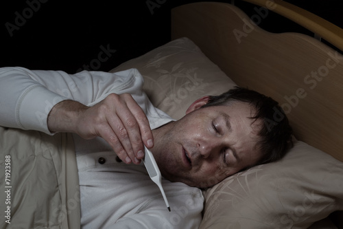 фотографія Sick Man testing his temperature for flu or virus