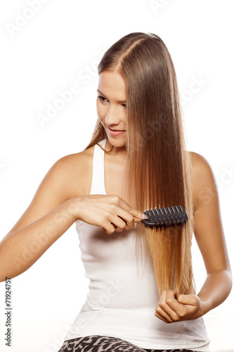 Foto smiling beautiful girl combs her long hair