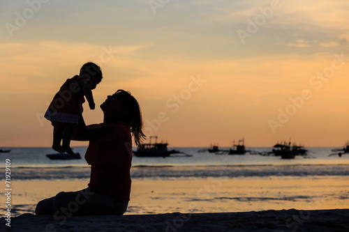 happy mother and baby at sunset beach