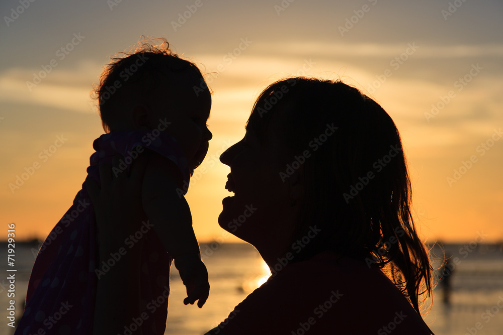 happy mother and baby at sunset beach