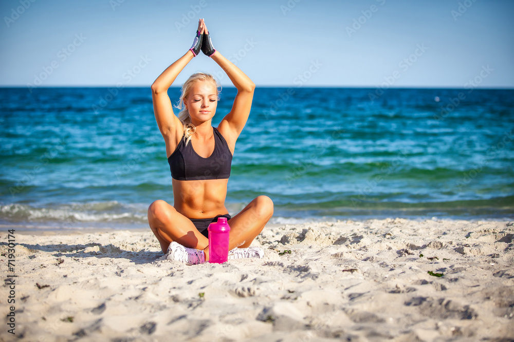 beautiful young woman sitting in yoga pose at the beach beautiful young woman sitting in yoga pose at the beach