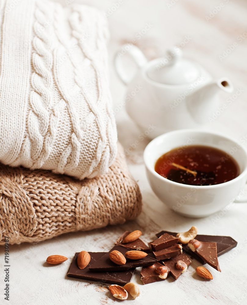 Cup of hot drink, knitting clothes, cinnamon and flowers. winter