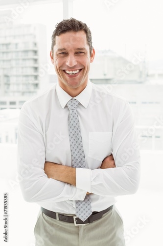 Happy businessman with arms crossed in office © WavebreakMediaMicro