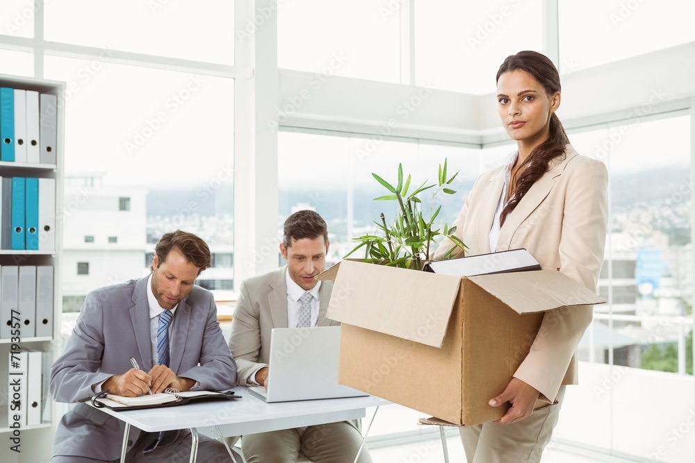 Businesswoman carrying her belongings in box Businesswoman carrying her belongings in box