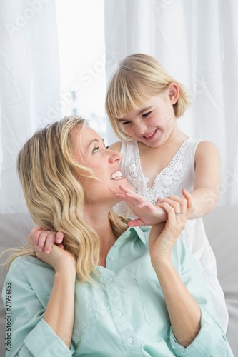 Portrait of a mother and daughter behind her on the couch