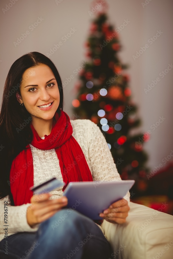 Pretty brunette shopping online with tablet at christmas Pretty brunette shopping online with tablet at christmas