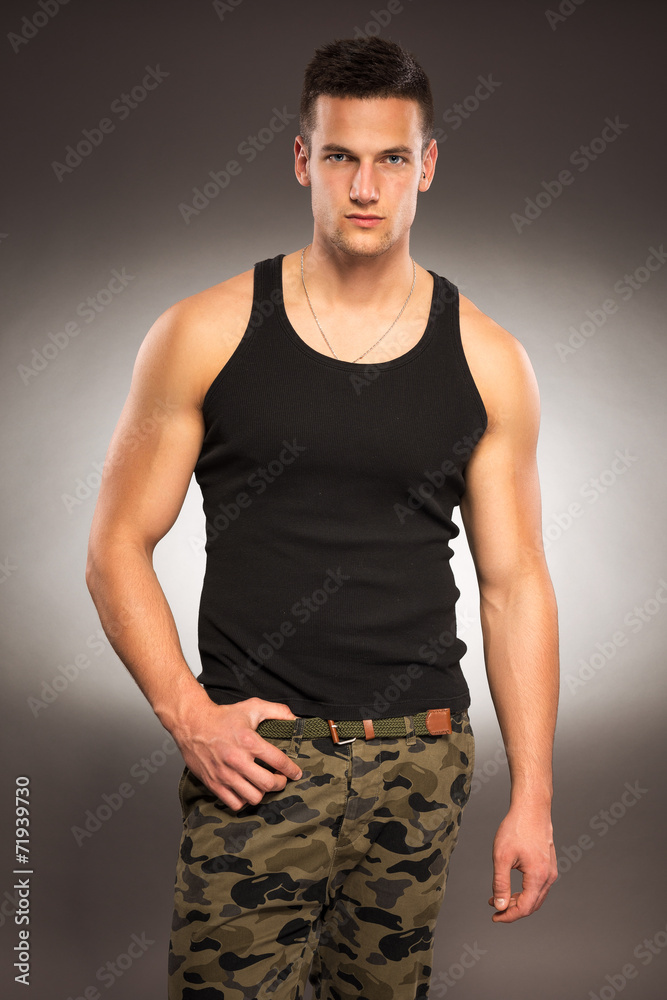 Muscular handsome man in black shirt and trousers terrain Muscular handsome man in black shirt and trousers terrain