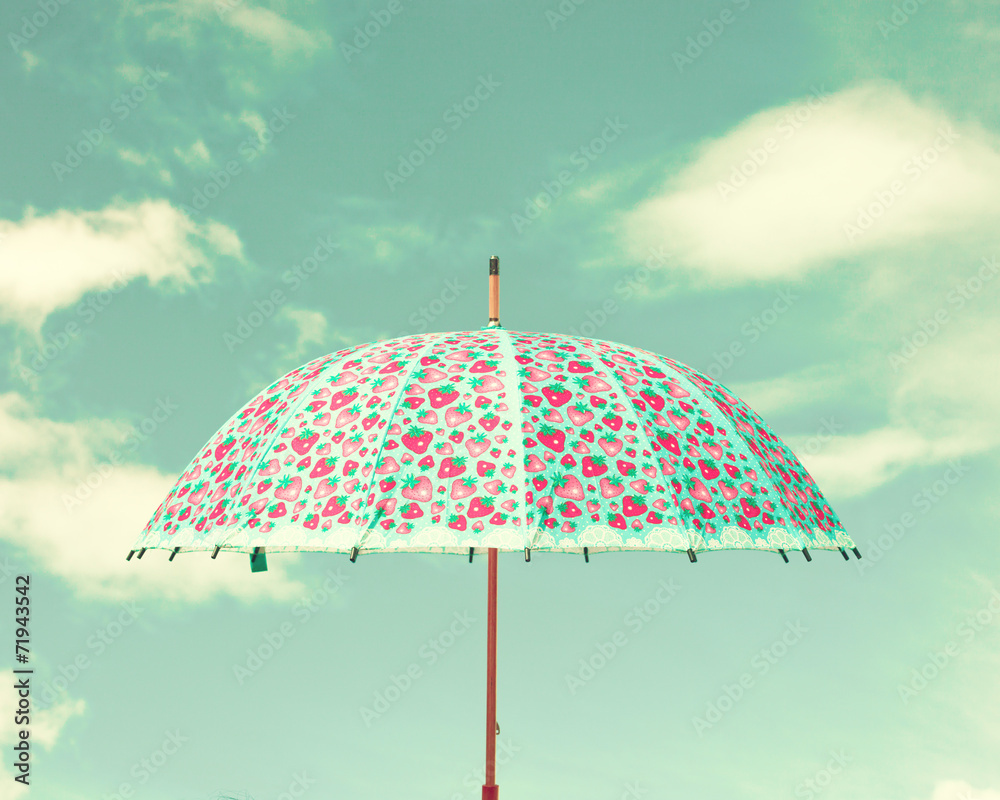 Vintage colorful umbrella and sky with clouds