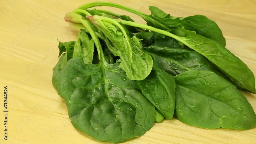 Spinach leaves spin on the background of wooden boards Spinach leaves spin on the background of wooden boards