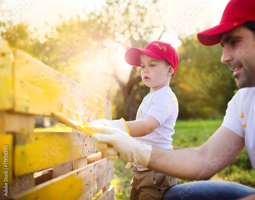 Father and son painting fence photo