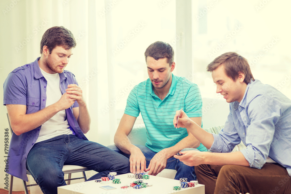 happy three male friends playing poker at home happy three male friends playing poker at home