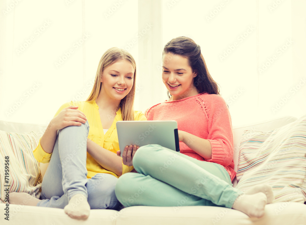 two smiling teenage girls with tablet pc at home two smiling teenage girls with tablet pc at home