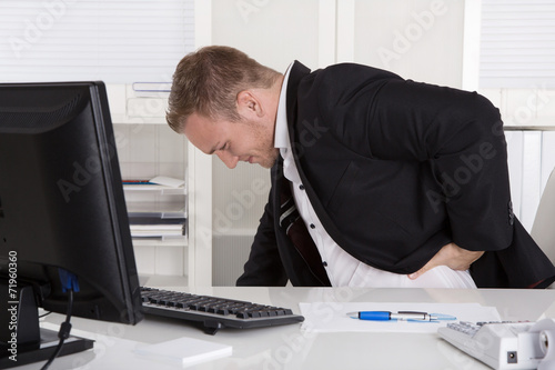 Business Mann mit Schmerzen im Büro: Rückenschmerzen photo