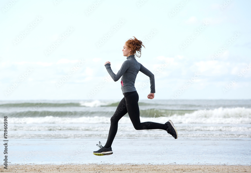 Healthy young woman running at the beach