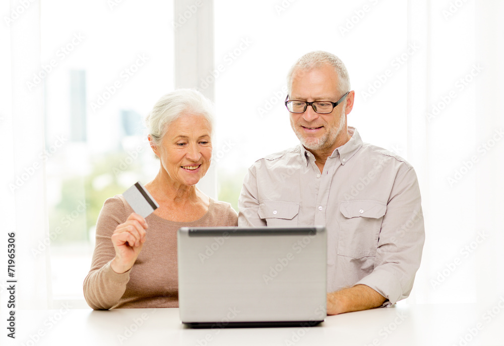 happy senior couple with laptop and credit card