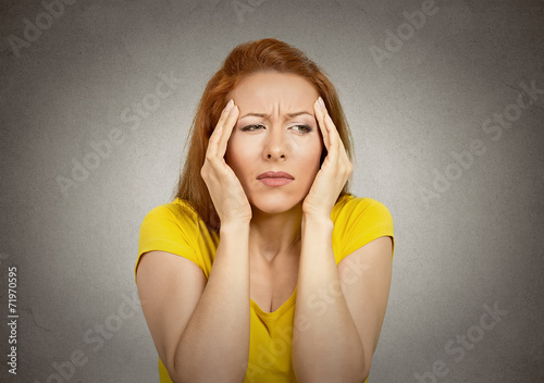 Headshot woman suffering from headache on grey background 