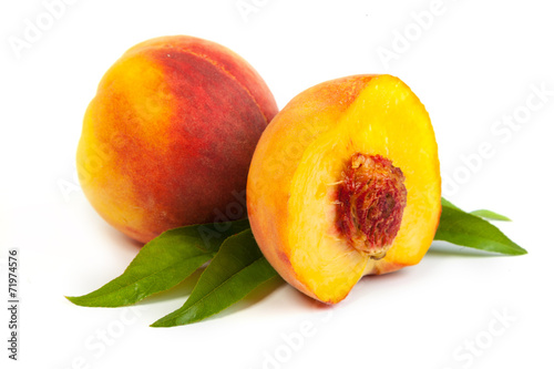 Three perfect, ripe peaches with a half and slices isolated on