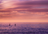 Couple paddle boarding at sunset