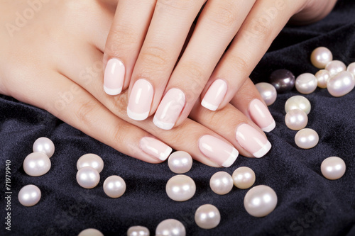 Beautiful woman's nails with french manicure and pearls. photo