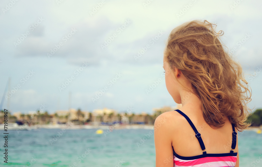 Naklejka premium Sad little girl looking at the sea.