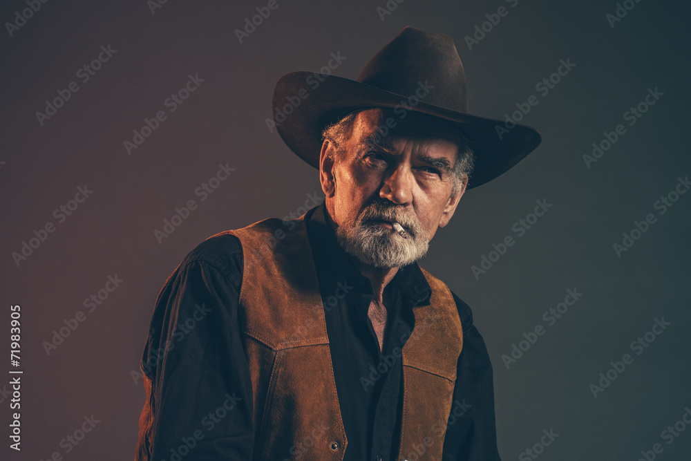 Cigarette smoking old rough western cowboy with gray beard and b Cigarette smoking old rough western cowboy with gray beard and b