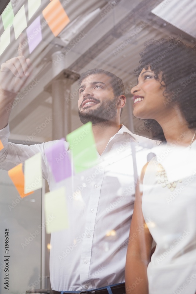 Obraz premium Casual business team looking at sticky notes