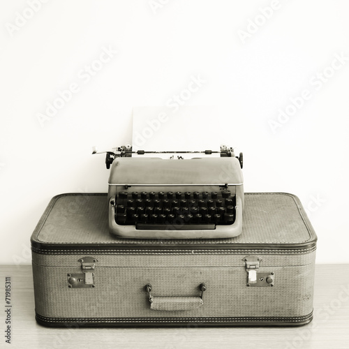 Vintage typewriter over suitcase