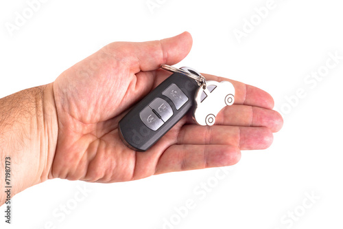 Male hand holding a car key isolated on white