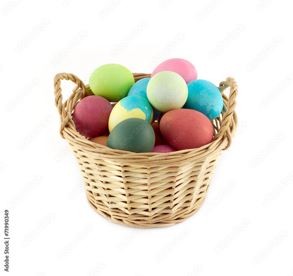 Color Easter eggs in brown basket front view isolated