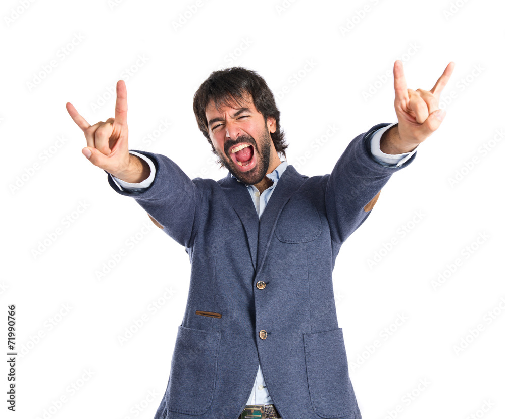 Man making horn gesture over white background