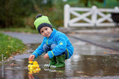 Fototapeta Naklejka Na Ścianę i Meble -  Little boy, jumping in muddy puddles