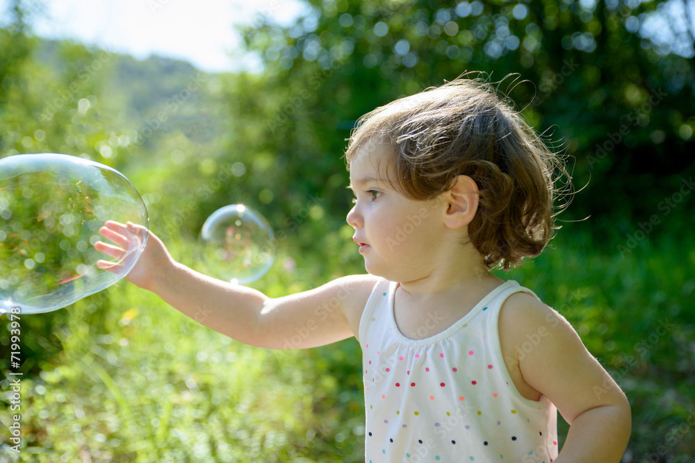 a little girl playing with soap bubbles a little girl playing with soap bubbles