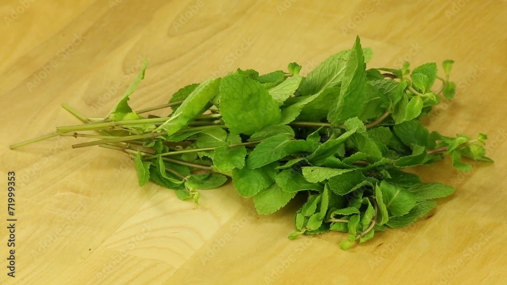 Bunch of mint rotates on a wooden boards background Bunch of mint rotates on a wooden boards background
