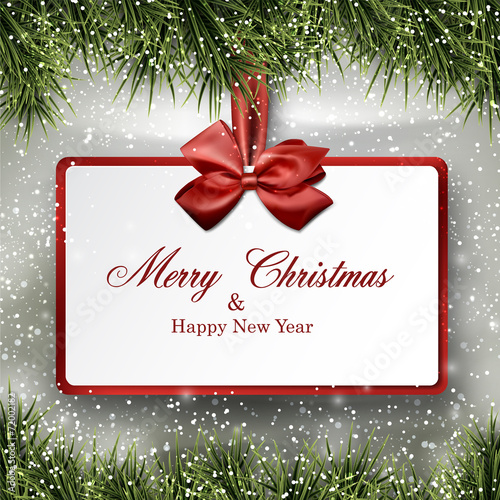 Paper gift card on frame with spruce branches.