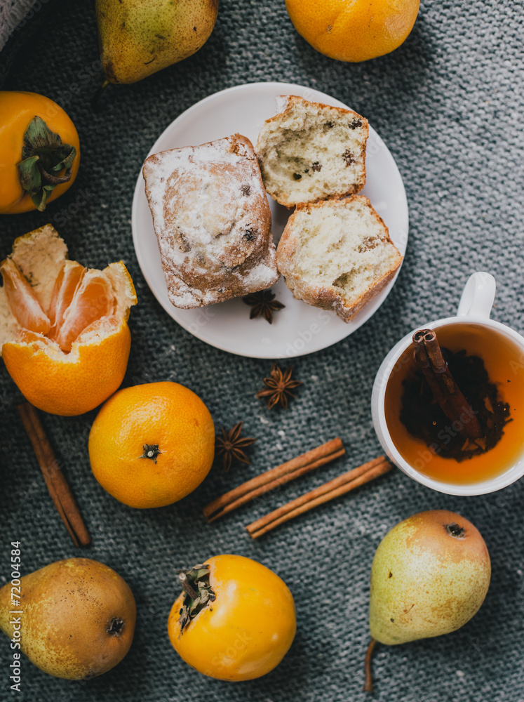 Tea, cinnamon sticks, muffins, pears, star anise and persimmons Tea, cinnamon sticks, muffins, pears, star anise and persimmons