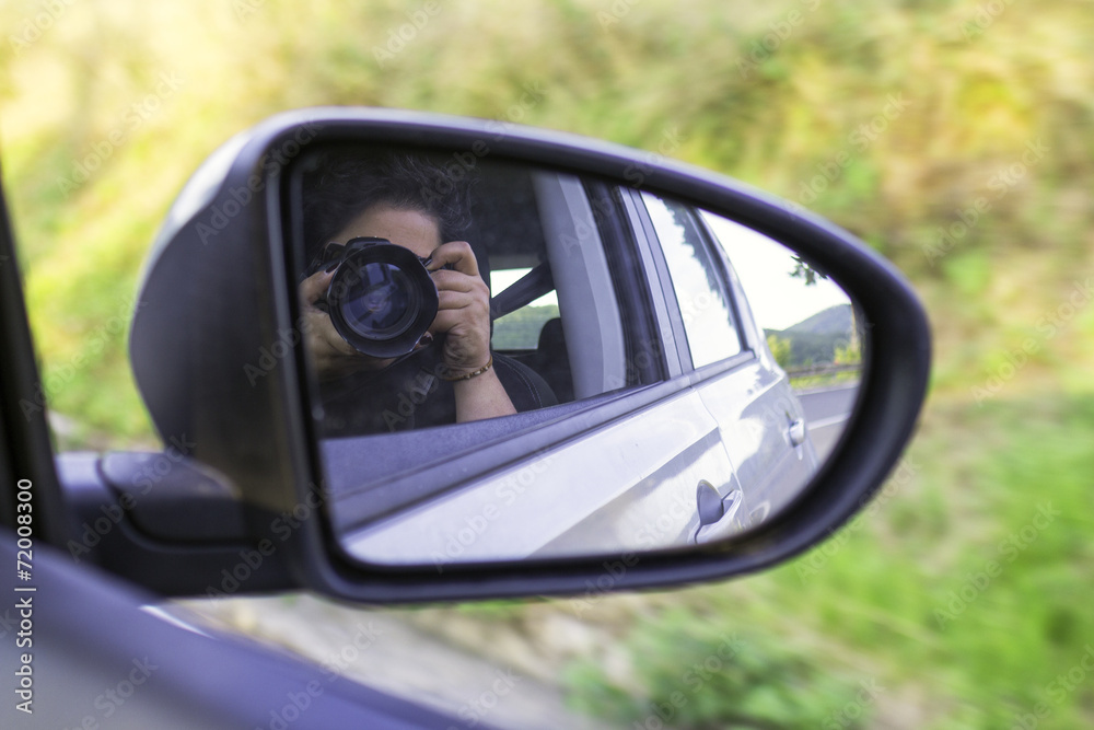 Photographer self portrait in a car mirror. Color image