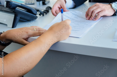 A woman signs a purchase document