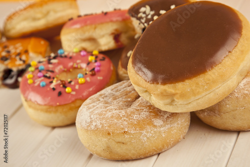 Colorful fresh doughnuts on yellow background