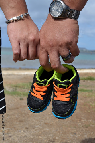 Parents holding baby shoes on the Beach