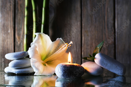 Spa set on mirror surface on wooden wall background