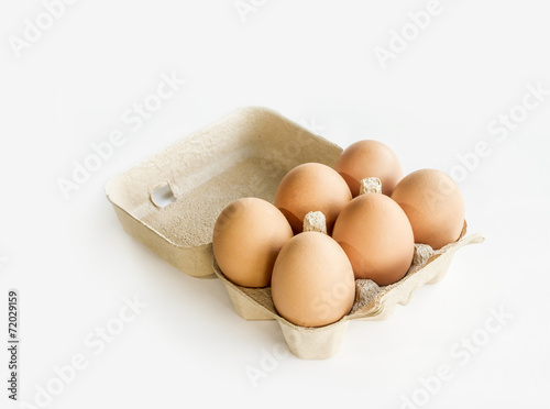 6 farm fresh chicken eggs in a tray over white.