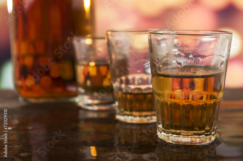 shots of rum whiskey over defocused lights background