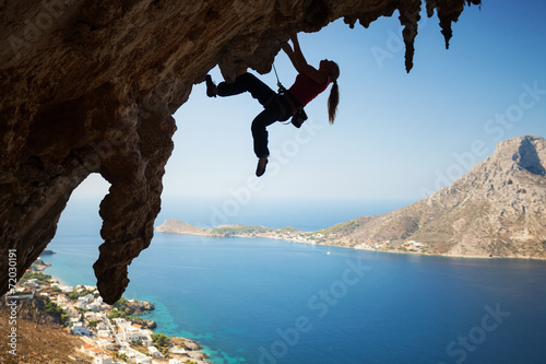 Silhouette of a young female rock climber on cliff