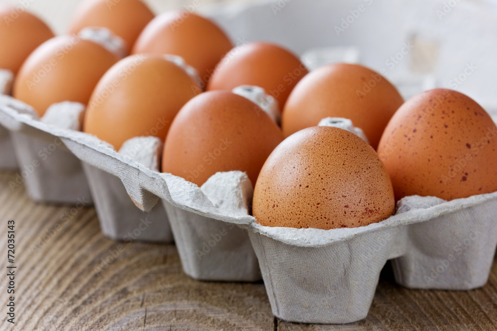 Chicken eggs in a carton box on a wooden rustic table Chicken eggs in a carton box on a wooden rustic table